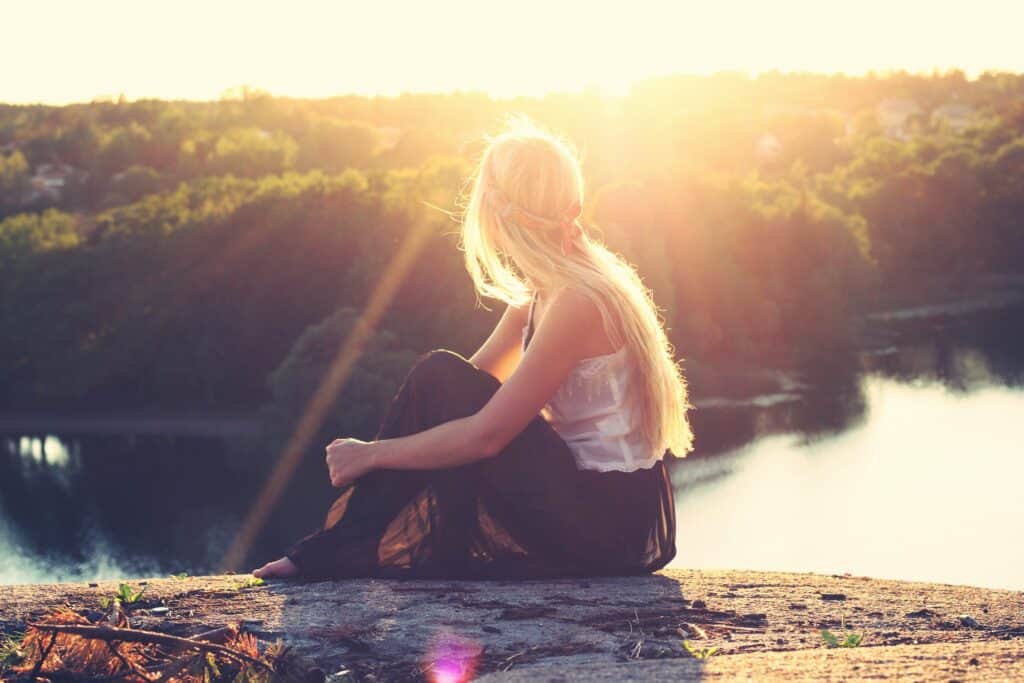 Woman sitting on the shore line thinking