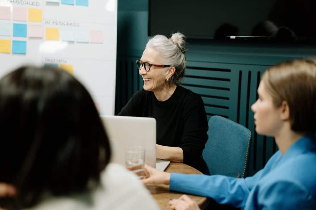 Women sitting at table discussing Computing
